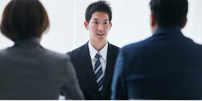 Candidate in a suit speaking with two interviewers during an investment banking interview. ChatGPT can make mistakes. Check important info.