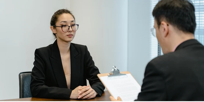 Candidate speaking with an interviewer across a desk.