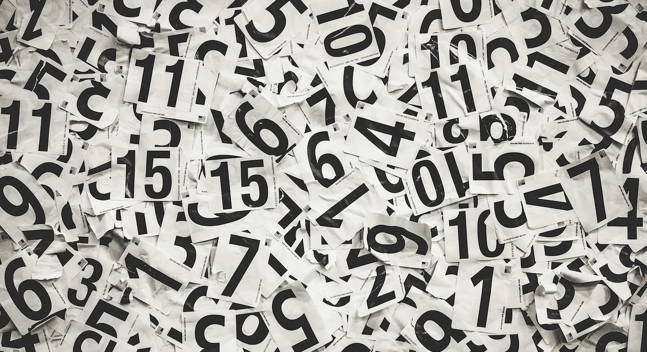Black-and-white scattered number cards featuring various digits arranged in an overlapping pattern