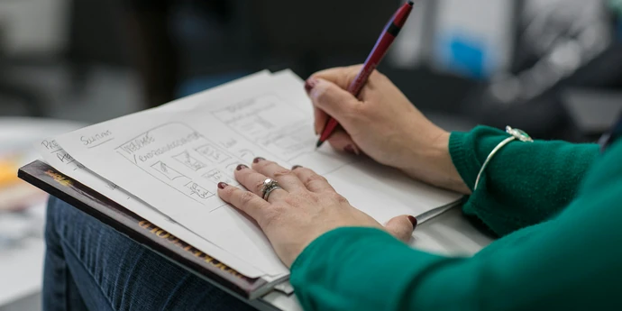 close up of notebook with scribbled outline on how to answer product design questions