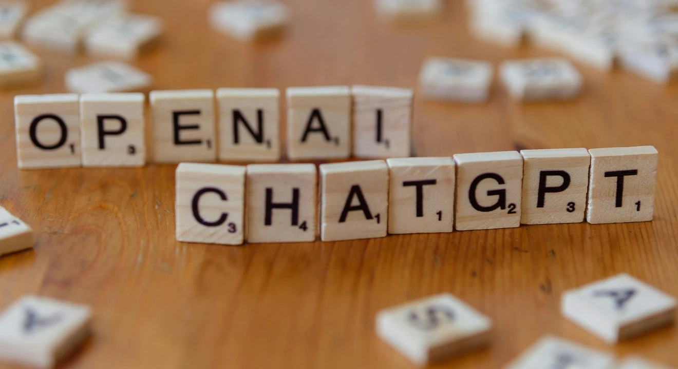 Wooden letter tiles spelling 'OPENAI CHATGPT' on a wooden surface, focused image