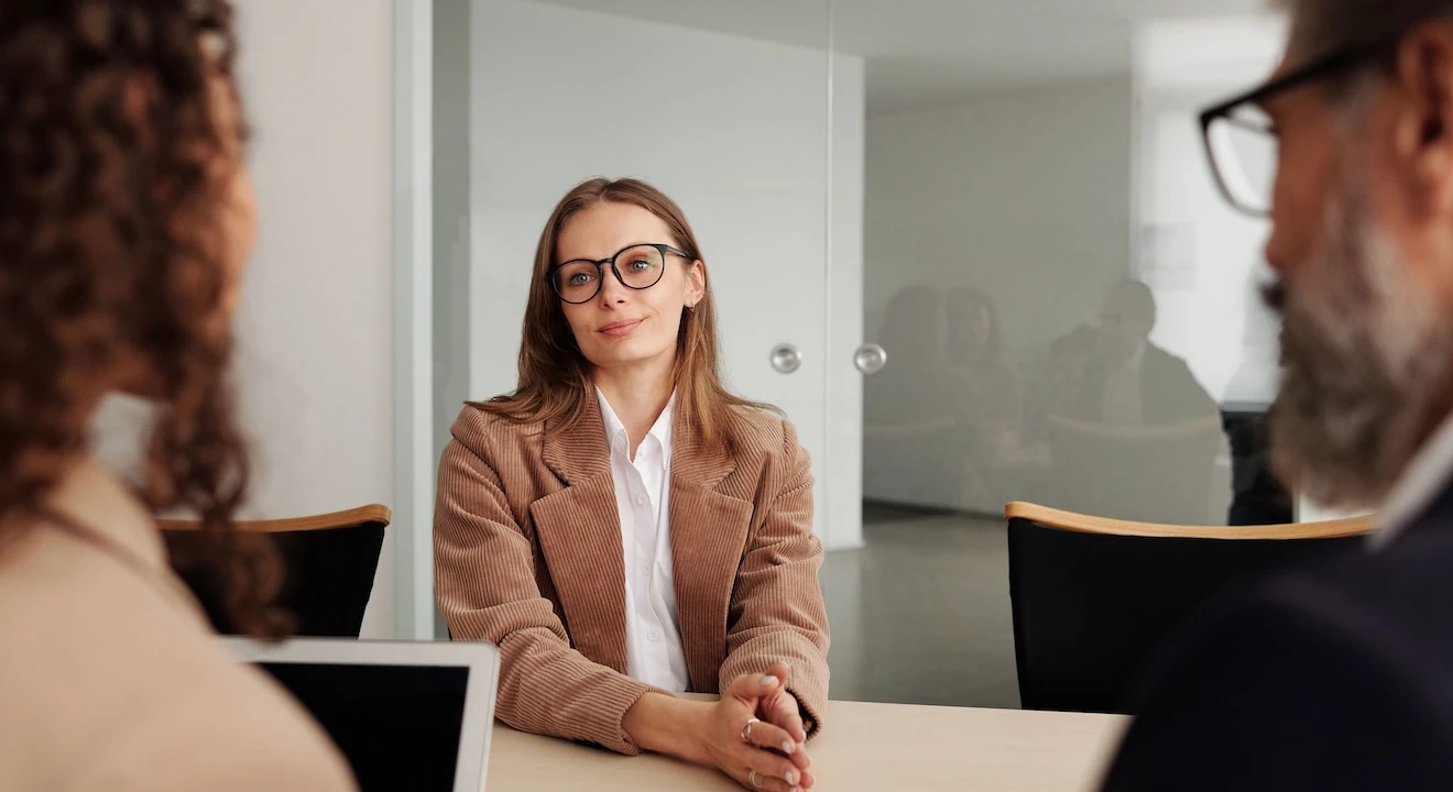 Job candidate interviewing with two hiring managers in a modern office