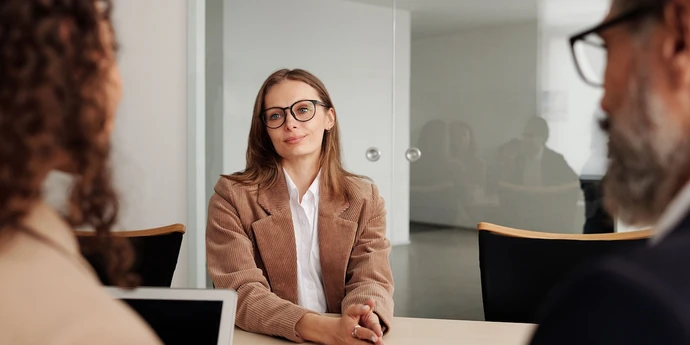 Job candidate interviewing with two hiring managers in a modern office