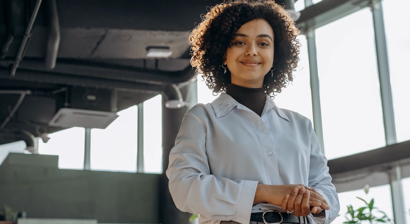 Professional woman standing confidently in a modern office