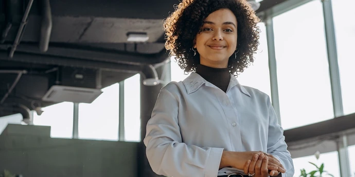 Professional woman standing confidently in a modern office
